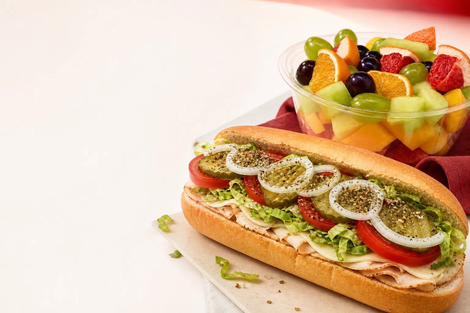 Fresh deli sandwich and fruit bowl from Crimson Deli